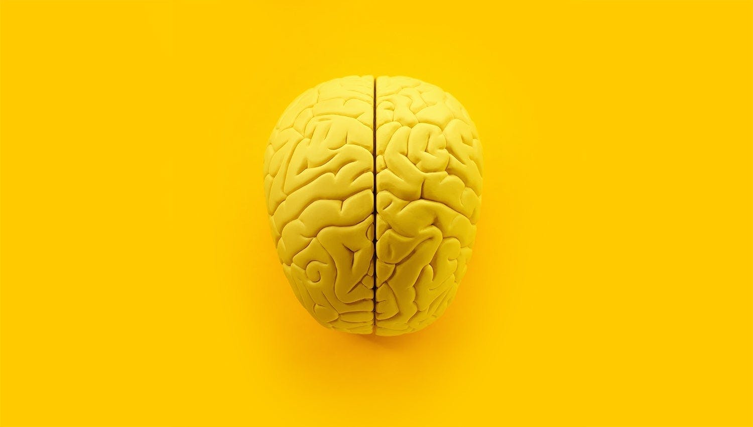 A yellow human brain representing the intersection of human intelligence and Artificial Intelligence in healthcare.